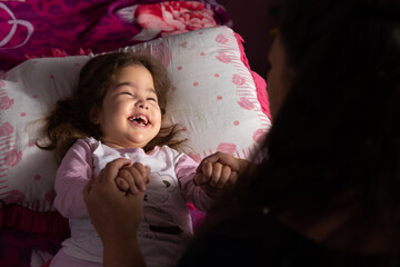 disabled baby laughing and having fun with mother in bedroom..