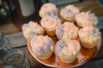 Gourmet artisan flower frosted cupcakes, pink, yellow, purple