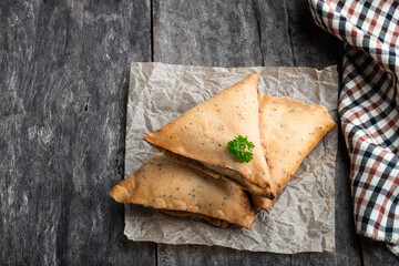Homemade vegetable fried indian samosas on wooden table