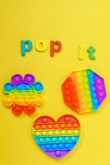 Colorful anti stress touch pop it toy. On a yellow background. Top view