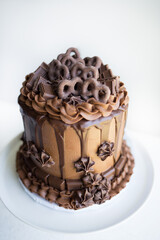 Triple Chocolate Cake with Chocolate-Covered Pretzels on a White Background