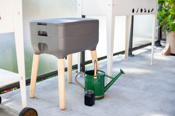 A vermicomposting system (worm composter) sits on an apartment balcony with other patio planters....