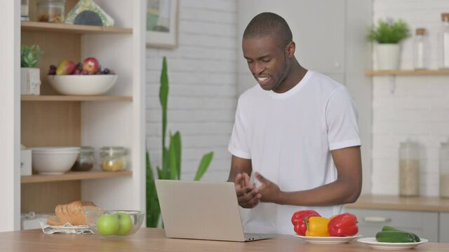 Athletic African Man doing Video Call on Laptop in Kitchen