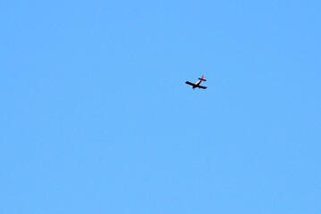 Fototapeta na wymiar Against the background of a huge blue spring sky, we see a flying plane