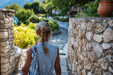 Fototapeta premium A tourist woman on the walking path in Agios Nikitas village on Lefkas Ionian Island, Greece
