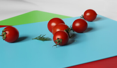 cherry tomatoes and greens on a blue chopping board