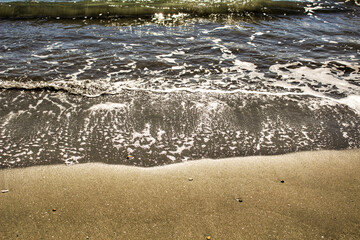 Waves, light and sand texture in the morning