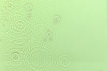 Green transparent clear water surface texture with ripples, splashes and bubbles Abstract summer nature background Mint colored waves in sunlight with copy space Cosmetic moisturizer micellar emulsion