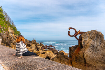 Fototapeta premium A young tourist visiting the Peine del Viento in San Sebastián. Province of Gipuzkoa, Basque Country. Spain