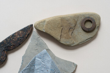 abstract composition with ironwork object, stones, paper, and metallic washer - photographed from...