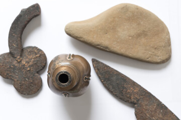 sand stone and upside down brass door knob with vintage ironwork objects on white