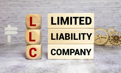 LLC Limited Liability Company written on a wooden cube in a office desk