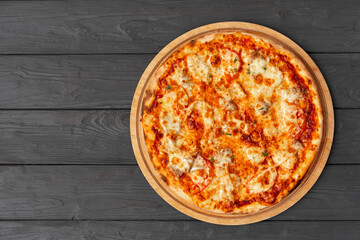 Tasty pizza on black wooden background top view