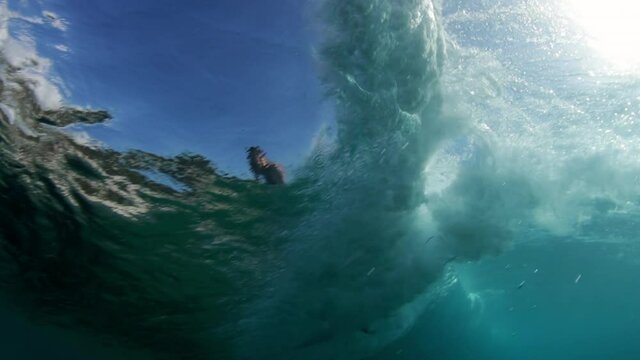 Close-Up Shot Of Tourist Surfing Over Waves In Ocean, Sunlight Falling In Underwater - Oahu, Hawaii