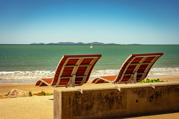 Modern reclined beach chairs along the sandy beach