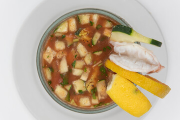 Overhead view of shrimp cocktail with sliced cucumber and citrus served in large goblet in tangy red sauce as an appetizer