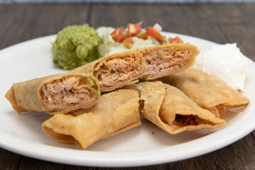 Tasty side order of deep fried chicken taquitos individually rolled and sliced into pieces on a plate