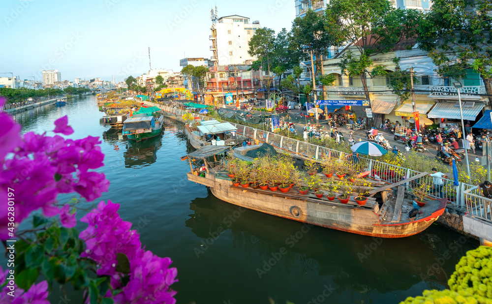 Wall mural Flowers boat at flower market along canal wharf. This place Farmers sell apricot blossom and other flowers on Lunar New Year in Ho Chi Minh city, Vietnam