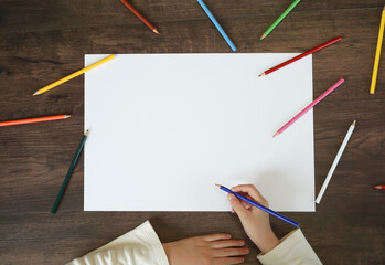 Blank material of the drawing paper. A child trying to draw a picture with colored pencils....
