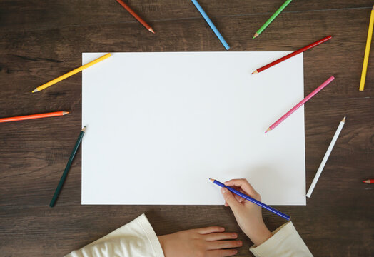 Blank material of the drawing paper. A child trying to draw a picture with colored pencils. 画用紙のブランク素材。色鉛筆で絵を描こうとしている子供。