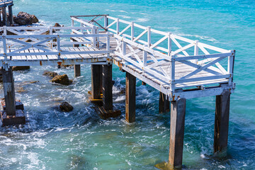 Old white wooden bridge walkway over sea beach, Sang Wan beach Koh Larn, Pattaya, Thailand