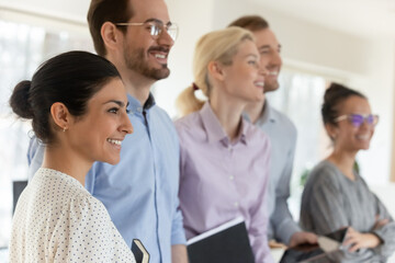Close up happy diverse motivated employees team standing in office, smiling successful confident...