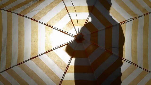 Anonymous Man Opening a Beach Umbrella Outdoors - 4K Resolution