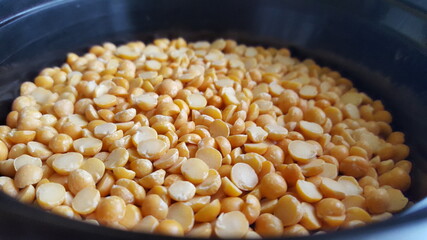 A close-up shot of a heap of raw split peas or Dahl.