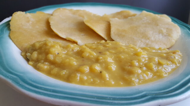 A close-up shot of some cooked split peas or Dahl and some round dumplings. 