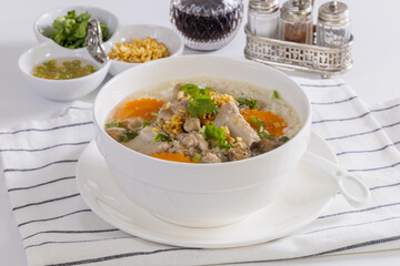 Pork boiled rice a white bowl on a table for breakfast.