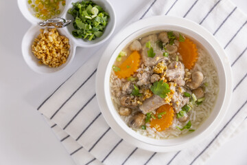 Pork boiled rice a white bowl on a table for breakfast.
