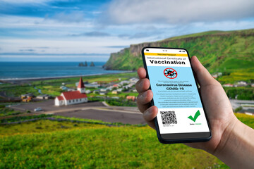 Traveler holds vaccine passport certificate to show COVID 19 vaccination status . The digital...