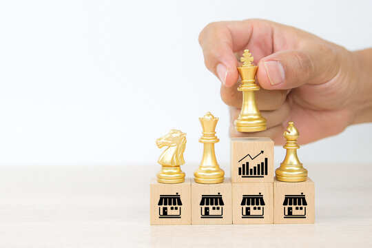 King and bishop and knight chess standing teamwork on cube wooden toy block stack with graph and franchises business store icon for growth and branch expansion and bank loan.