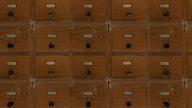 From left to right in front of the camera are moving very old shabby catalog boxes without labels. Seamless loop.