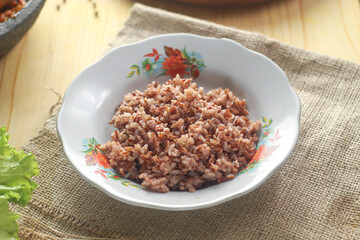 selected focus of Red rice, a variety of rice that is colored red by its anthocyanin content. It is usually eaten unshelled or partially hulled, and has a red husk, rather than the more common brown. 