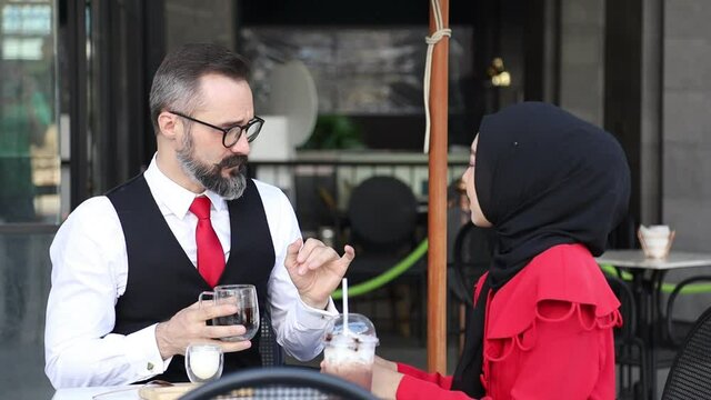 Arabic businessman has meeting and discussing with Muslim lady at the halal coffee shop for Muslim culture concept