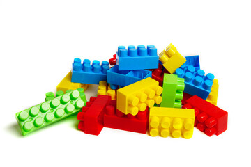 Multi-colored plastic designer building blocks on a white background. Colorful construction kit for kids
