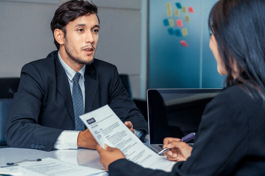 Human resource manager interviewing the male employment candidate in the office room. Happy job interview. Job application, recruitment and Asian labor hiring concept.