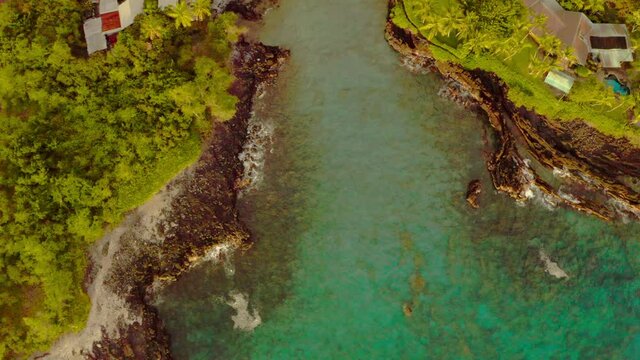 Aerial Top Upward Shot Of Sea Water Flowing Amidst Landscape During Sunset - Big Island, Hi