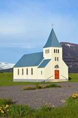 scenic lutheran church with mountain backdrop on a sunny summer day  in hofsos, iceland