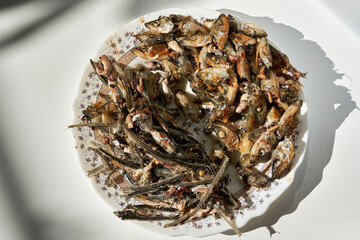 Fish heads and bones left after eating on a plate.