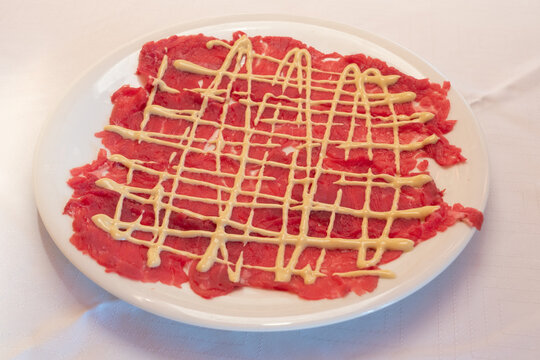 Beef Carpaccio with Mayonnaise Sauce in Classic Cipriani Style on a White Plate
