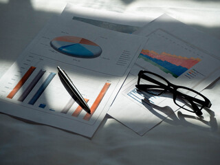 Business background, financial stock sales analysis concept with financial data, glasses and pen