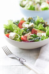 Salad with Green Olives, Tomatoes and Feta Cheese. Bright wooden background. 