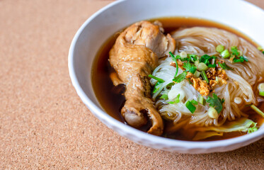 Thai Food, Thin Chicken Noodle Soup With vegetables and chicken drumsticks in white bowls, On top view