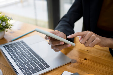 Close up view of businesswoman typing on smart phone while sitting in office.