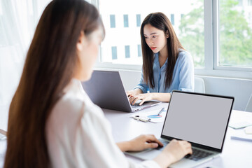 Two young Asian woman are focused on working