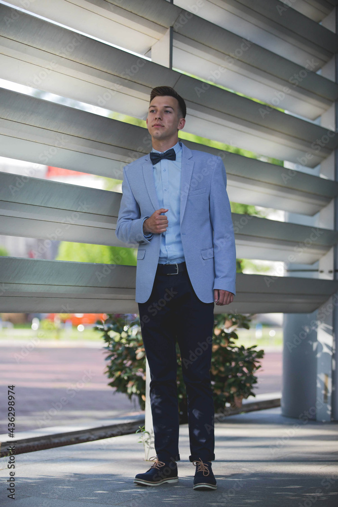 Wall mural young elegant caucasian man wearing an expensive blue suit at an event