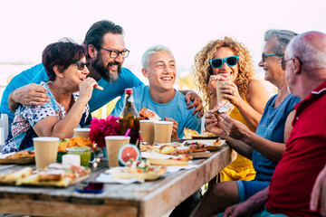 Family group celebrate and have fun together in friendship outdoor at home with a table full of...