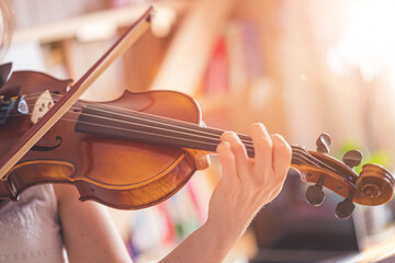 Practicing classical music and violin concept: Young girl happily plays on her new violin
